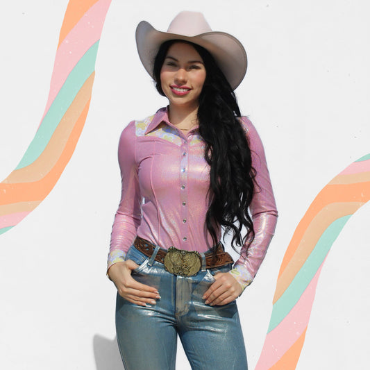 Woman wearing a pink rodeo shirt, blue jeans, and a cowboy hat with a colorful abstract background
