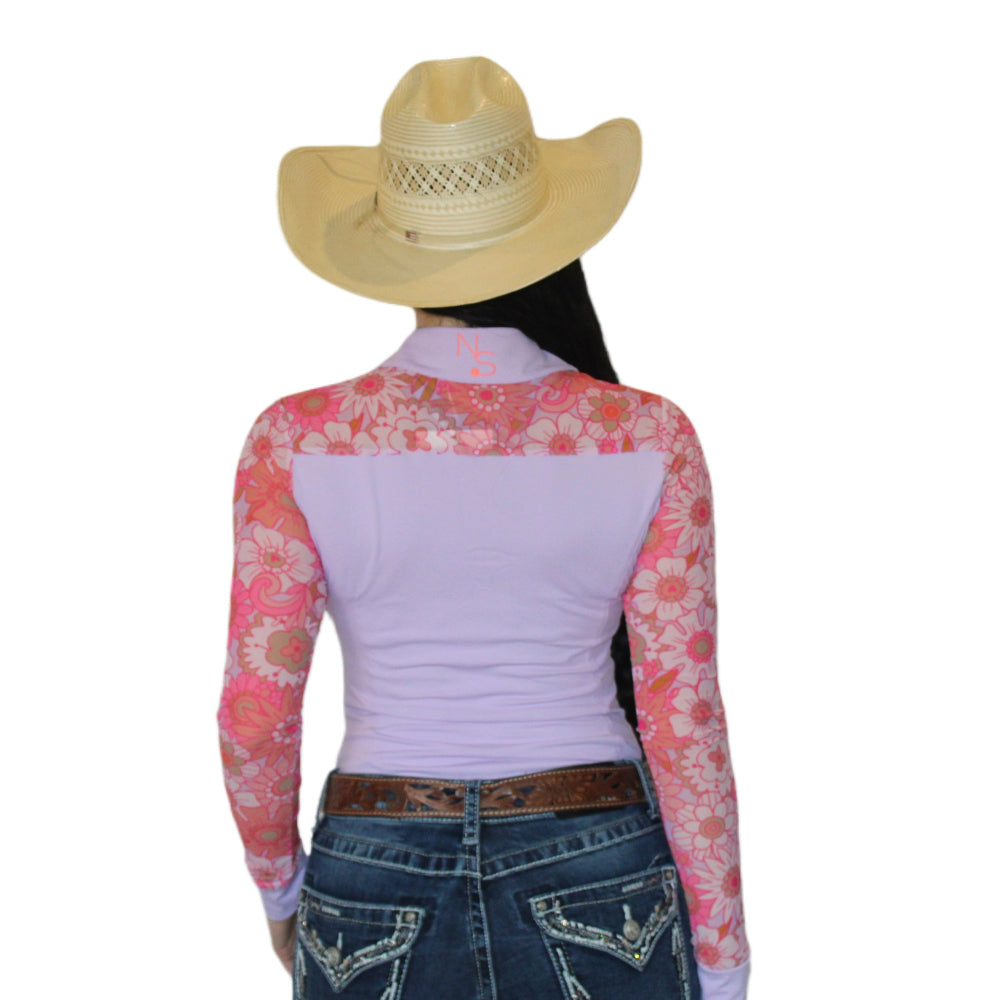 Woman wearing a light pink and peach mesh rodeo shirt with floral sleeves showing the back of the shirt.