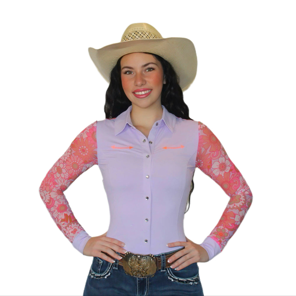 Woman wearing a light pink and peach mesh rodeo shirt with floral sleeves.