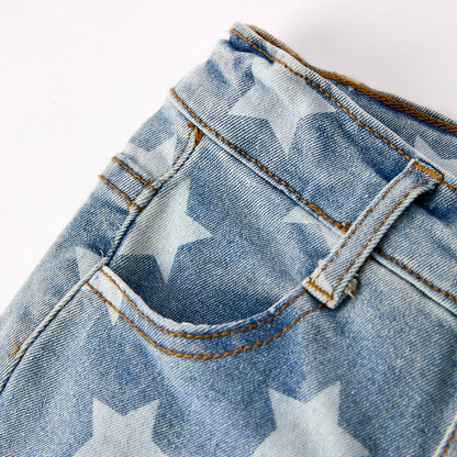 Close-up of kids and toddler denim western jeans fabric with star pattern on a white background