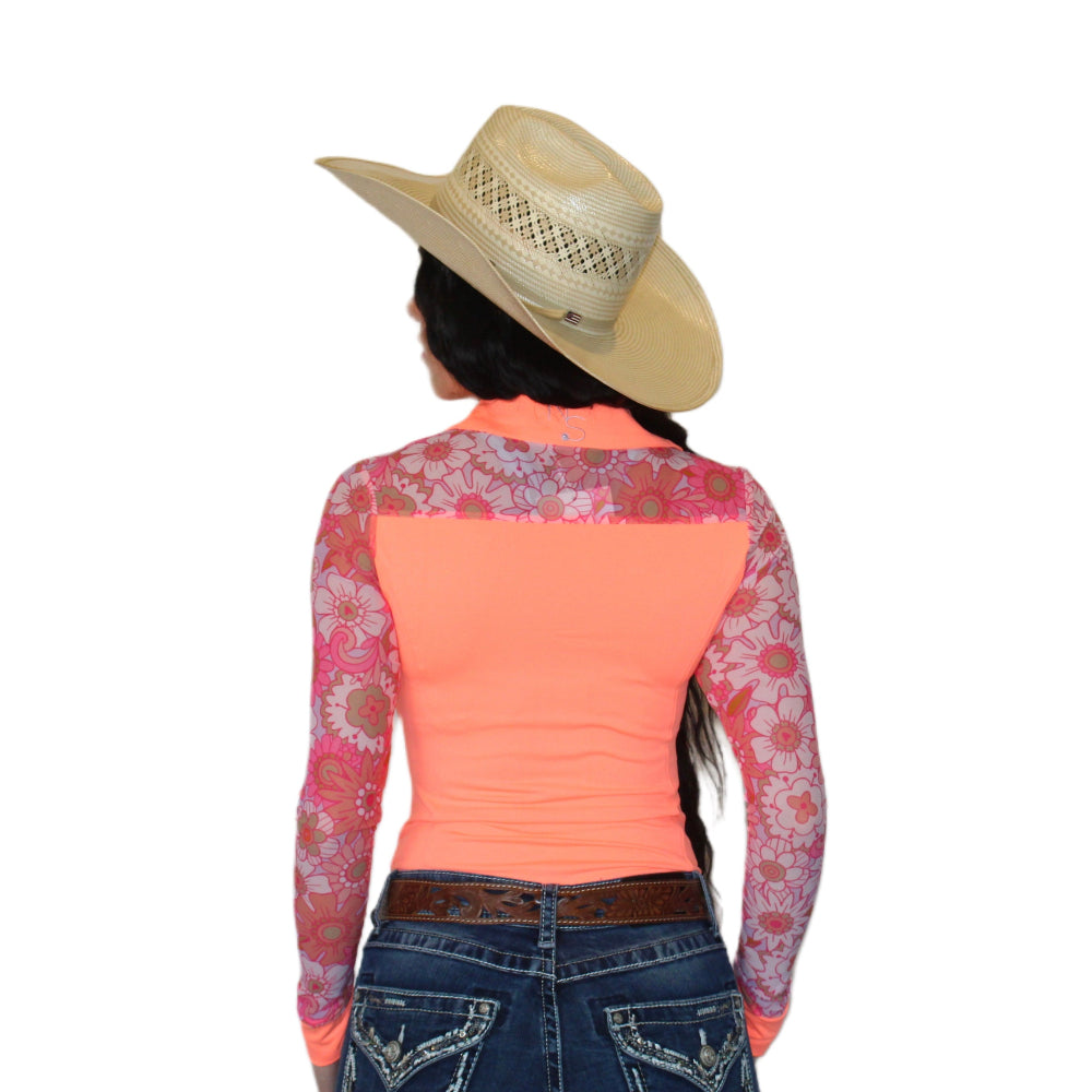 Person wearing a pink floral long-sleeve mesh rodeo shirt and blue jeans with a straw hat on a white background