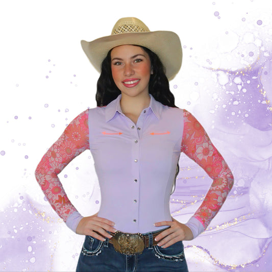 Woman wearing a light pink and peach mesh rodeo shirt with floral sleeves, blue jeans, and a straw hat on a white background.