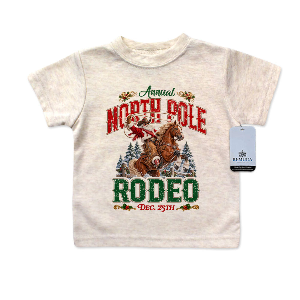 A colorful North Pole Christmas Rodeo Infant Western Santa T-shirt in the color Oatmeal with a solid white background.