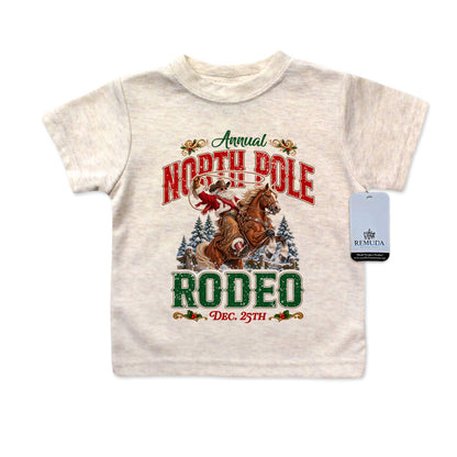 A colorful North Pole Christmas Rodeo Infant Western Santa T-shirt in the color Oatmeal with a solid white background.