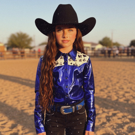 Girl wearing an electric blue western rodeo shirt with a royal flush pattern and a black cowboy hat in an outdoor setting.
