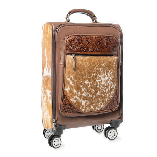 Brown and beige patterned hairon cowhide pattern and tooled leather carry on suitcase with decorative accents on a white background