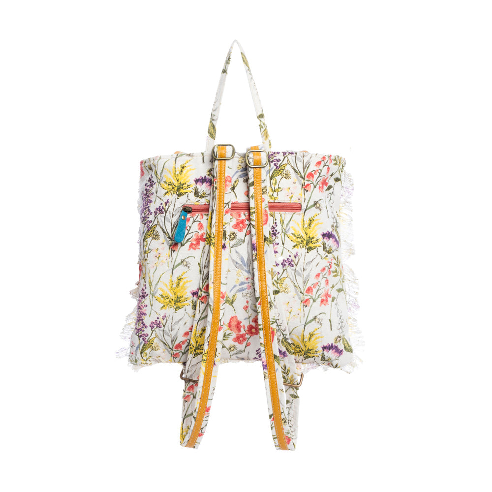 Floral-patterned tote bag backpack with leather accents on a white background