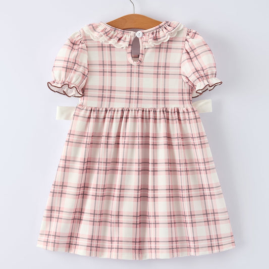 Back of pink plaid dress with horse design on a hanger against a white background