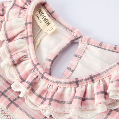 Collar of pink plaid dress with horse design on a hanger against a white background