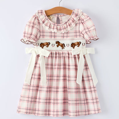Pink plaid dress with horse design on a hanger against a white background