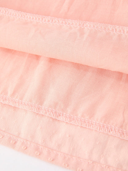 Close-up of a pink fabric with lace trim on a white background