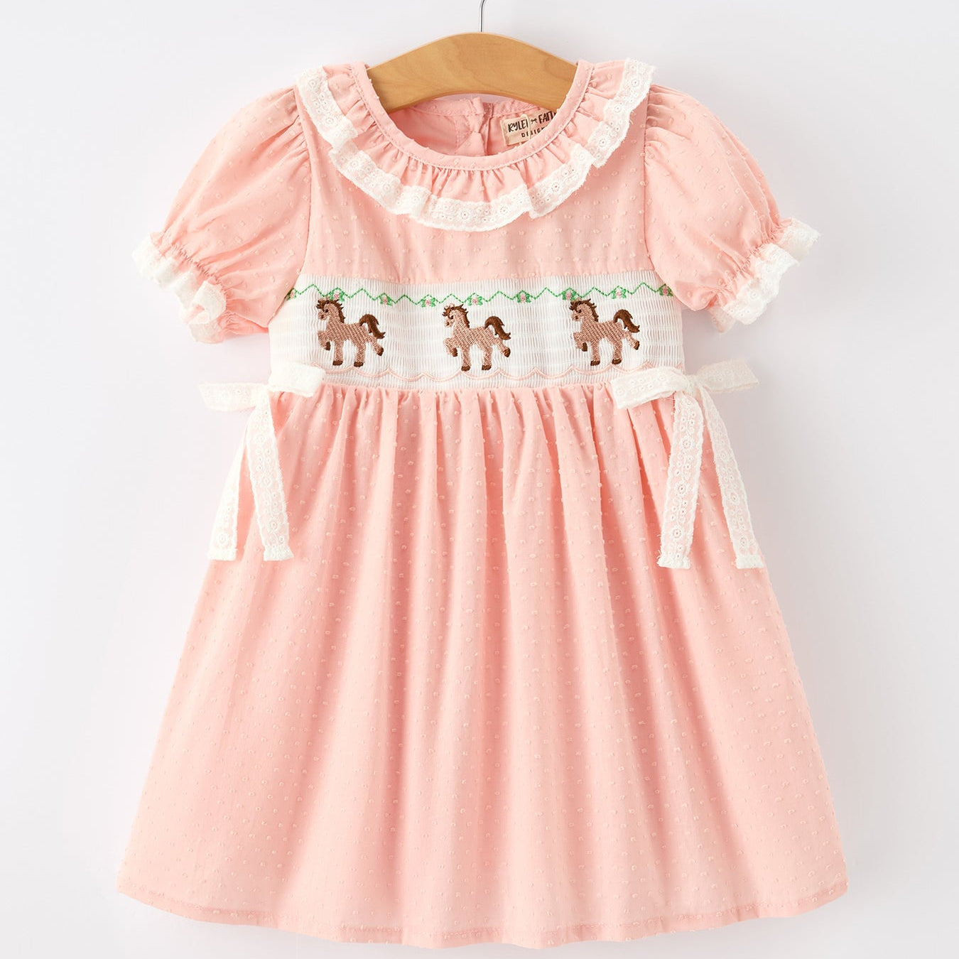 Pink dress with horse design on a white background