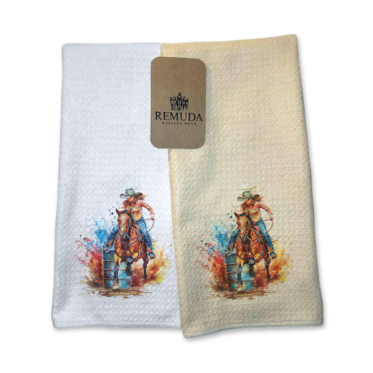 A set of vibrant western rodeo style kitchen hand towels featuring a barrel racer running around a barrel. Comes in cream and white colors. The design captures the spirit of rodeo and western culture.