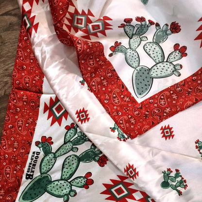 Close-up of a Wild Rag 100% Silk Cactus Red Bandana Border Cowboy Western Neck Scarf with Teal Green and Red colors. An exclusive design by Double B Wild Rags. Cactus, Aztec motif, with a classic red bandana border.