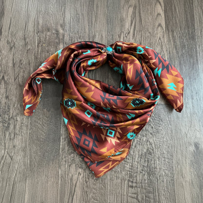 A Wild Rag with a chestnut brown, rust, turquoise, black Aztec tribal pattern.