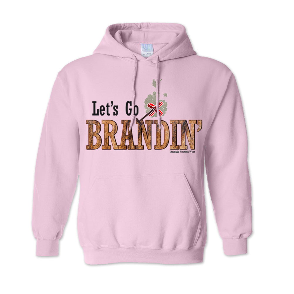 An adult vintage light pink colored hoodie with the phrase 'Let's Go Brandin'' printed in bold western letters across the chest. Above the text is an illustration of a classic western-style branding iron, emitting a faint glow of heat. The branding iron features a distinctive 'X' emblem, reminiscent of cattle branding. A great shirt for western wear, ranch wear, or rodeo wear.