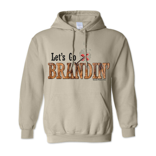 An adult vintage sand tan colored hoodie with the phrase 'Let's Go Brandin'' printed in bold western letters across the chest. Above the text is an illustration of a classic western-style branding iron, emitting a faint glow of heat. The branding iron features a distinctive 'X' emblem, reminiscent of cattle branding. A great shirt for western wear, ranch wear, or rodeo wear.