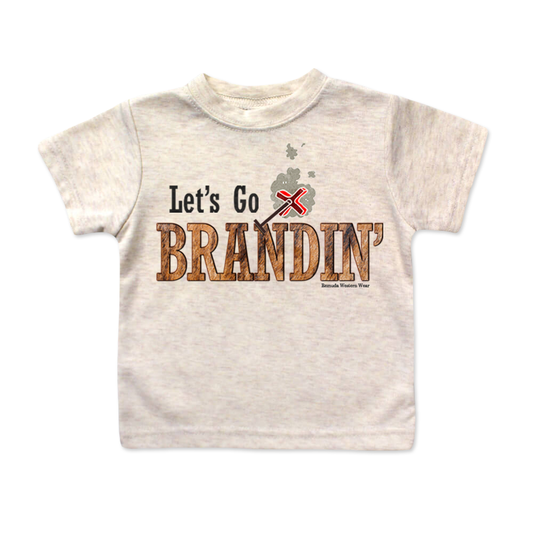 A stylish western-themed oatmeal colored infant t-shirt featuring the phrase 'Let's Go Brandin'' prominently printed in bold, weathered letters across the chest. Above the shirt is is an illustration of a branding iron, evoking a rustic cowboy aesthetic. Kids Western wear, Ranch wear and Rodeo wear.