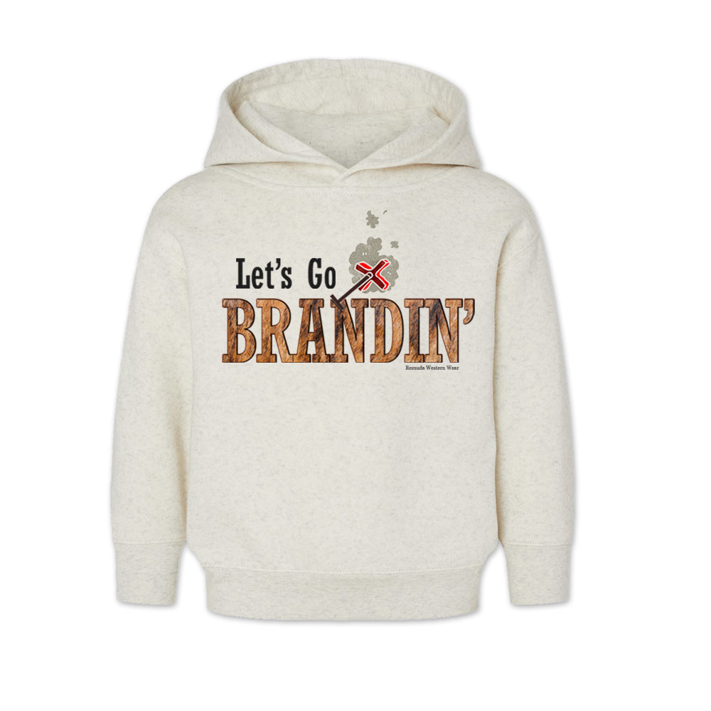 A vintage oatmeal colored toddler hoodie with the phrase 'Let's Go Brandin'' printed in bold western letters across the chest. Above the text is an illustration of a classic western-style branding iron, emitting a faint glow of heat. The branding iron features a distinctive 'X' emblem, reminiscent of cattle branding. A great shirt for kids western wear, ranch wear, or rodeo wear.