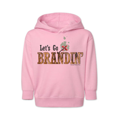 A vintage light pink colored toddler hoodie with the phrase 'Let's Go Brandin'' printed in bold western letters across the chest. Above the text is an illustration of a classic western-style branding iron, emitting a faint glow of heat. The branding iron features a distinctive 'X' emblem, reminiscent of cattle branding. A great shirt for kids western wear, ranch wear, or rodeo wear.