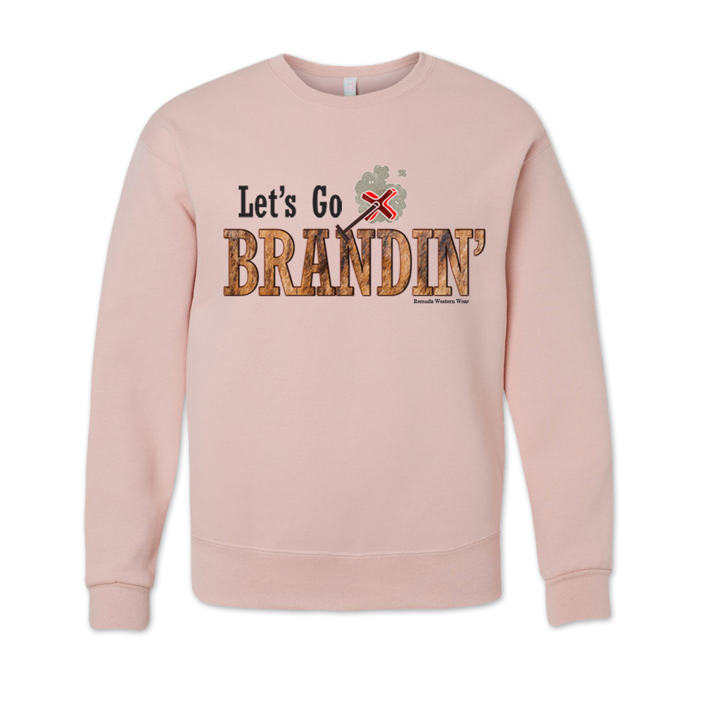 An adult vintage pink blush colored sweatshirt with the phrase 'Let's Go Brandin'' printed in bold western letters across the chest. Above the text is an illustration of a classic western-style branding iron, emitting a faint glow of heat. The branding iron features a distinctive 'X' emblem, reminiscent of cattle branding. A great shirt for western wear, ranch wear, or rodeo wear.