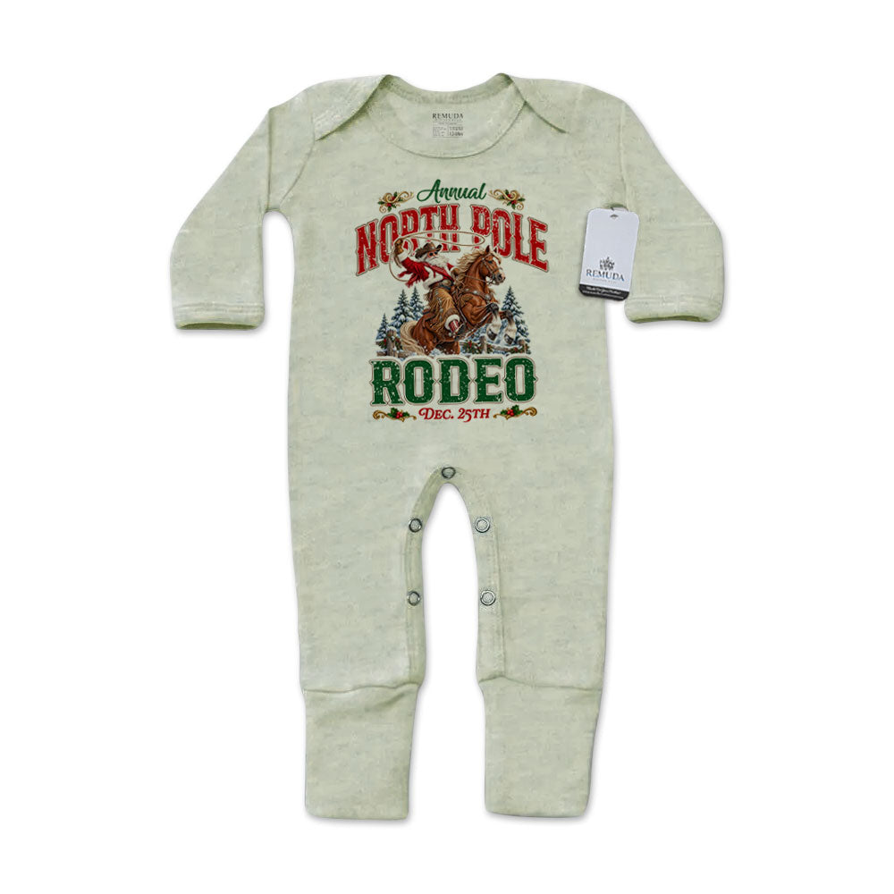 Heather Sage Green-colored infant one-piece footed pajamas featuring a festive North Pole Rodeo Christmas graphic with cowboy Santa riding a rearing horse, red and green lettering, long sleeves, and snap closures.