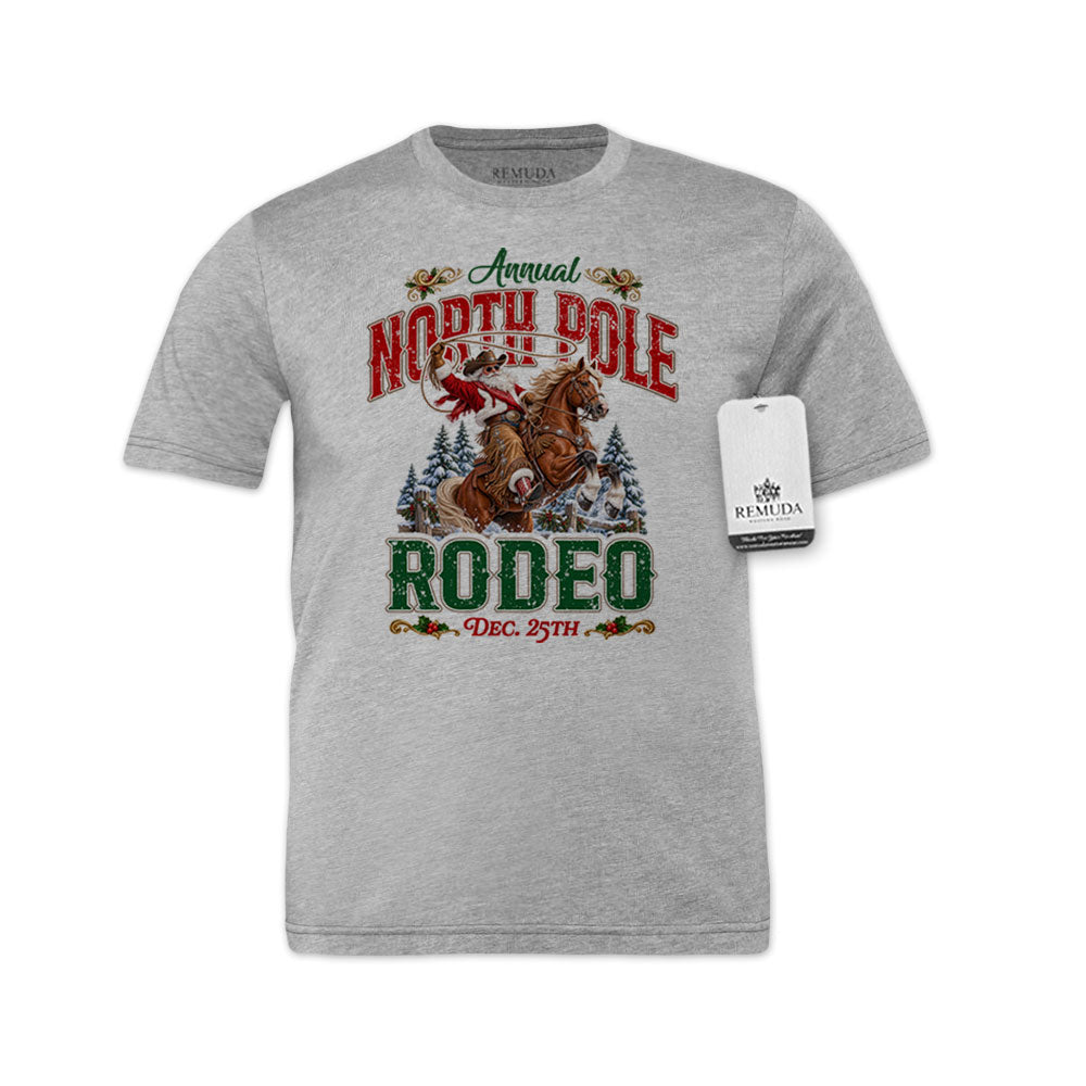 Athletic Heather Gray adult unisex short sleeve T-shirt featuring a festive North Pole Rodeo Christmas design with Cowboy Santa riding a rearing horse, snowy pine trees, vintage red and green Western lettering, December 25th details, and a classic crewneck style.