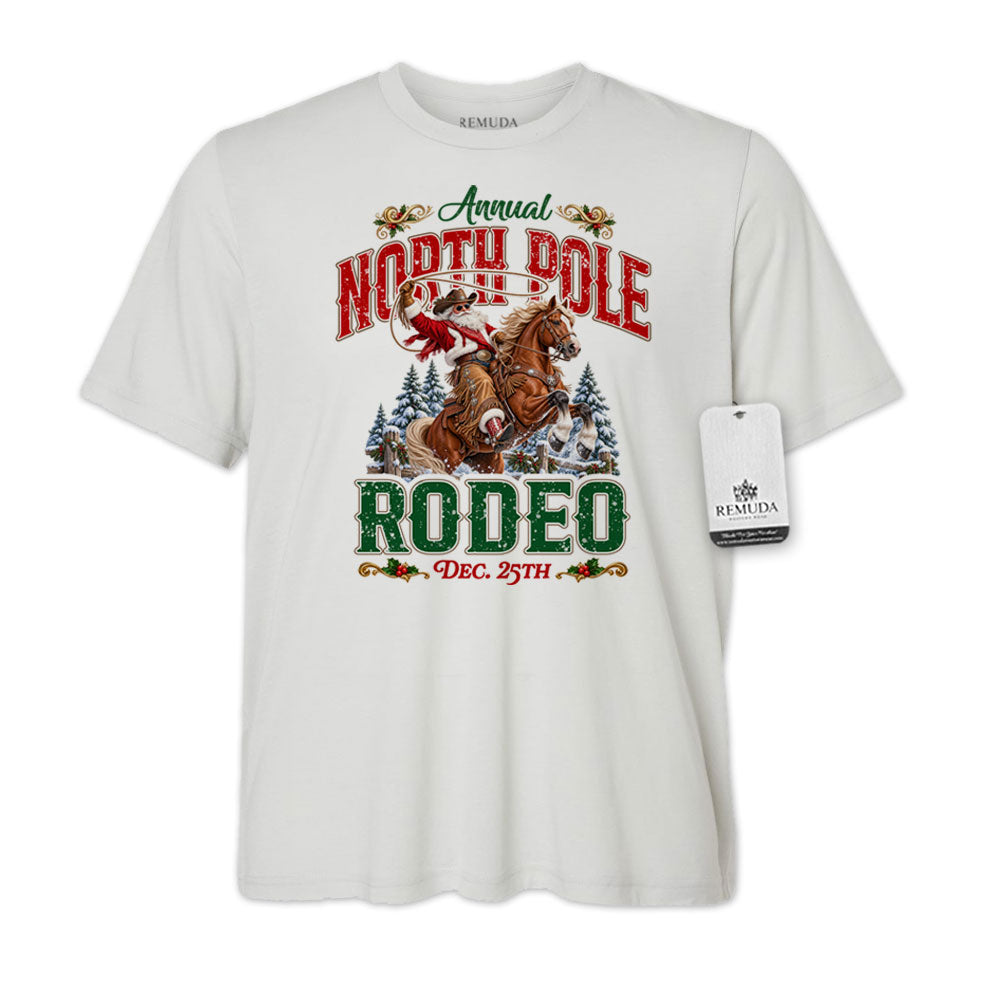 Solid Silver-color adult unisex short sleeve T-shirt featuring a festive North Pole Rodeo Christmas design with Cowboy Santa riding a rearing horse, snowy pine trees, vintage red and green Western lettering, December 25th details, and a classic crewneck style.