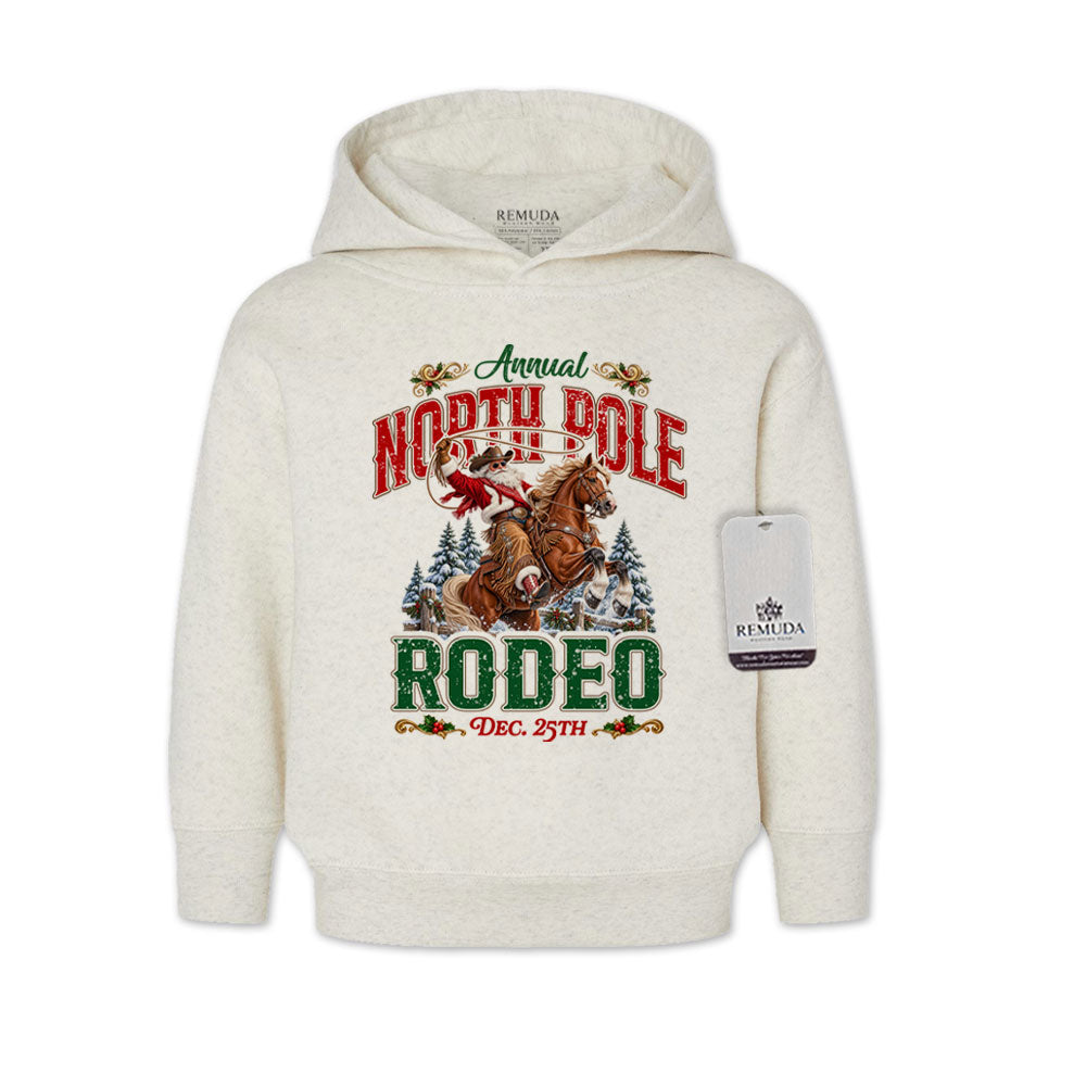 Oatmeal-colored toddler pullover hoodie featuring a festive North Pole Rodeo Christmas design with Cowboy Santa riding a rearing horse, snowy pine trees, vintage red and green lettering, December 25th details, and ribbed cuffs and hem.