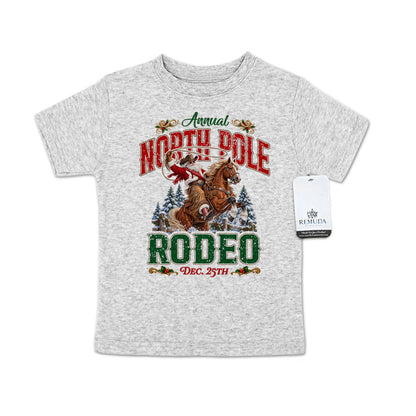 Heather gray toddler short sleeve T-shirt featuring a festive North Pole Rodeo Christmas design with Cowboy Santa riding a rearing horse, snowy pine trees, vintage red and green rodeo lettering, and December 25th details.