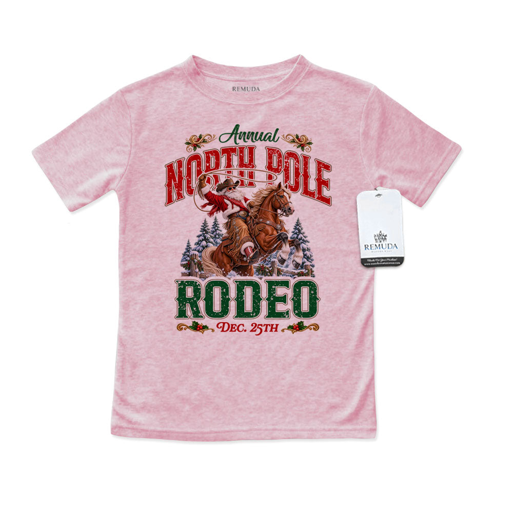 Pink toddler short sleeve T-shirt featuring a festive North Pole Rodeo Christmas design with Cowboy Santa riding a rearing horse, snowy pine trees, vintage red and green rodeo lettering, and December 25th details.