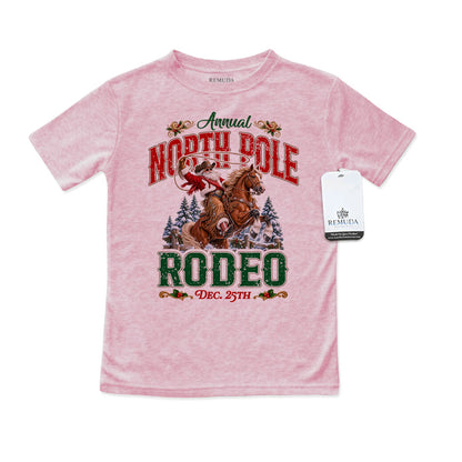 Pink toddler short sleeve T-shirt featuring a festive North Pole Rodeo Christmas design with Cowboy Santa riding a rearing horse, snowy pine trees, vintage red and green rodeo lettering, and December 25th details.