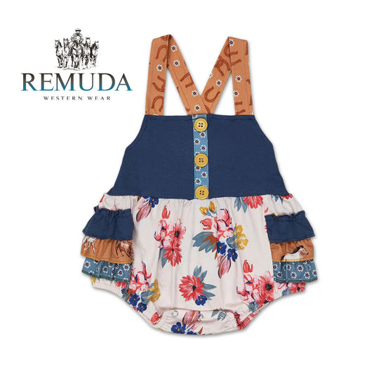 Western baby "Petals & Ponies" romper featuring a navy bodice, floral print, crossed back straps, ruffled side panels with running horses detail.