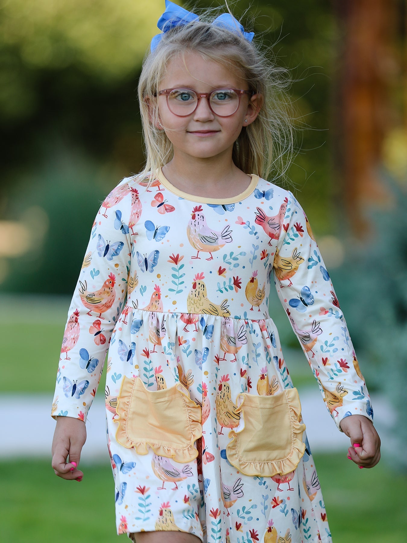 Young girl wearing a dress with farm animal print outdoors