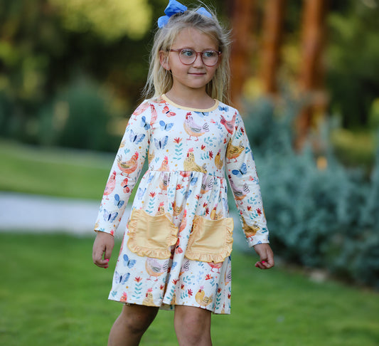 Young girl wearing a dress with chicken print outdoors