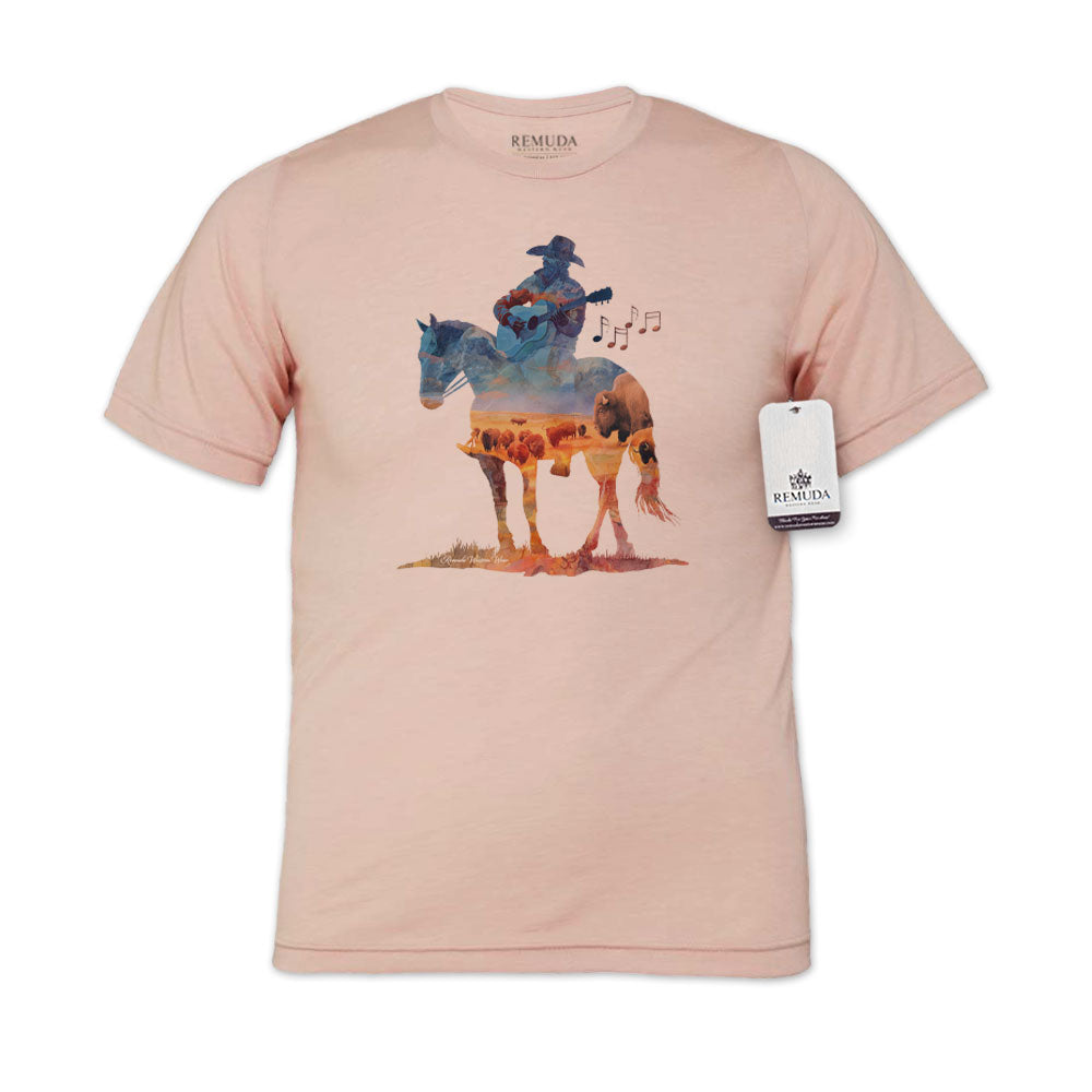 Watercolor-style illustration on a western peach colored t-shirt showing a cowboy on horseback playing a guitar, with a soft, artistic western aesthetic titled “Where The Buffalo Roam.”
