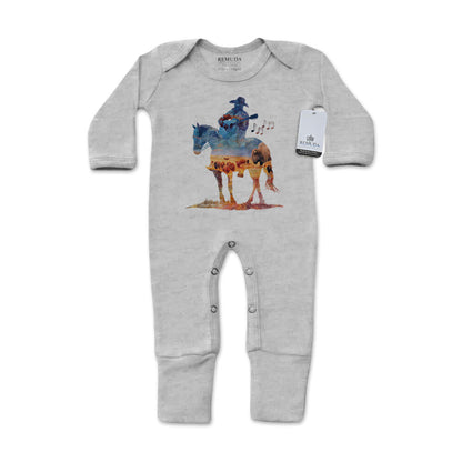 Infant one-piece footed gray colored sleepwear with built-in mittens featuring a watercolor-style design of a cowboy on horseback playing a guitar, titled “Where The Buffalo Roam,” in a soft, artistic western theme.