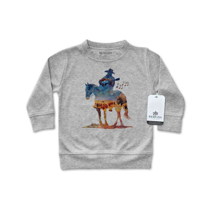 Watercolor-style illustration on an gray colored infant long sleeve pullover showing a cowboy on horseback playing a guitar, titled “Where The Buffalo Roam,” in a soft, artistic western design.