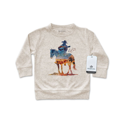 Watercolor-style illustration on an oatmeal colored infant long sleeve pullover showing a cowboy on horseback playing a guitar, titled “Where The Buffalo Roam,” in a soft, artistic western design.