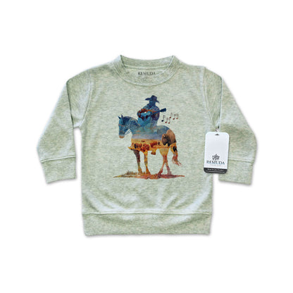 Watercolor-style illustration on an sage heather green colored infant long sleeve pullover showing a cowboy on horseback playing a guitar, titled “Where The Buffalo Roam,” in a soft, artistic western design.