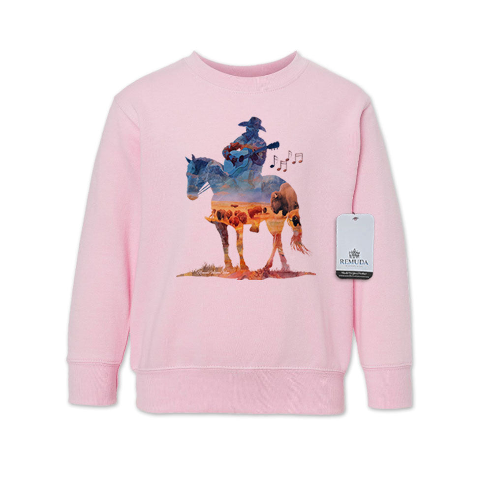 Watercolor-style illustration on a pink toddler sweatshirt showing a cowboy on horseback playing a guitar, with a playful western theme titled “Where The Buffalo Roam.”