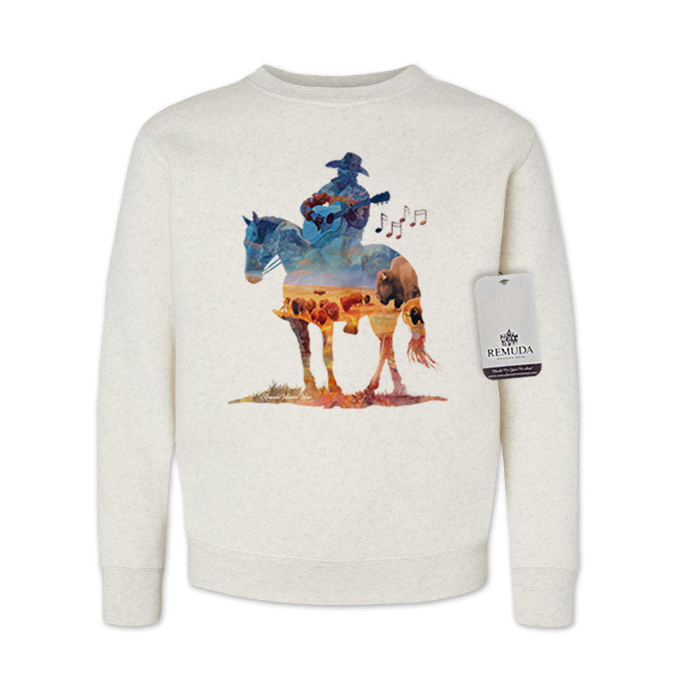 Watercolor-style illustration on an oatmeal youth sweatshirt showing a cowboy on horseback playing a guitar, with a playful and artistic western theme titled “Where The Buffalo Roam.”